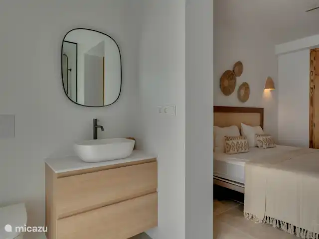 Luxe badkamer en-suite voorzien van wastafel, spiegel en toilet